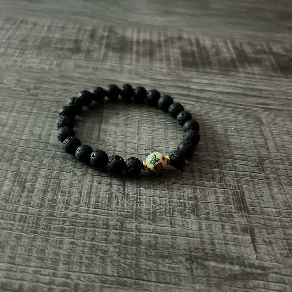 Lava stone beaded bracelet with Asian accent glass bead.